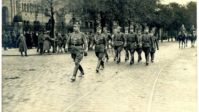 Przemarsz wojsk powstańczych przez ulice miasta. Z tyłu widać żołnierzy na koniach.