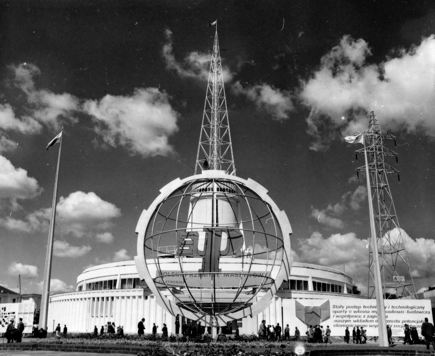 Black and white photo of a fair building - a spire which is a symbol of Poznań fair. In a foreground a sphere bearing the fair logo. - grafika artykułu