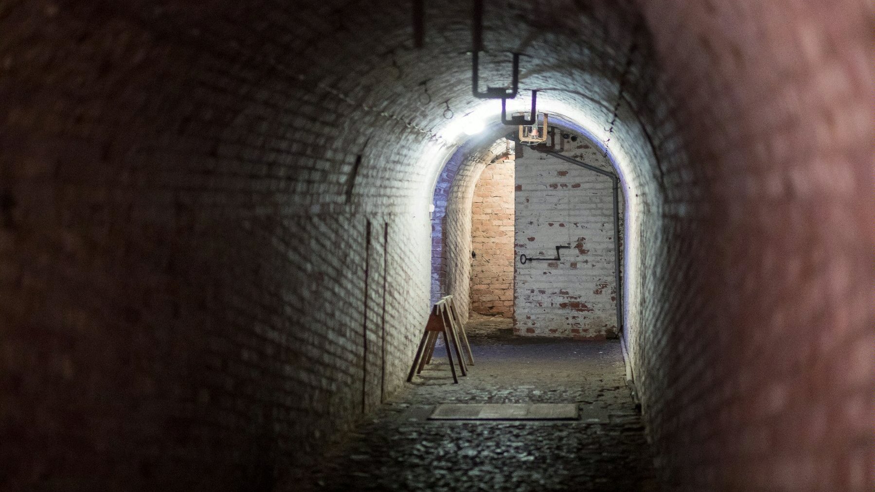 An underground corridor, illuminated by artificial light.