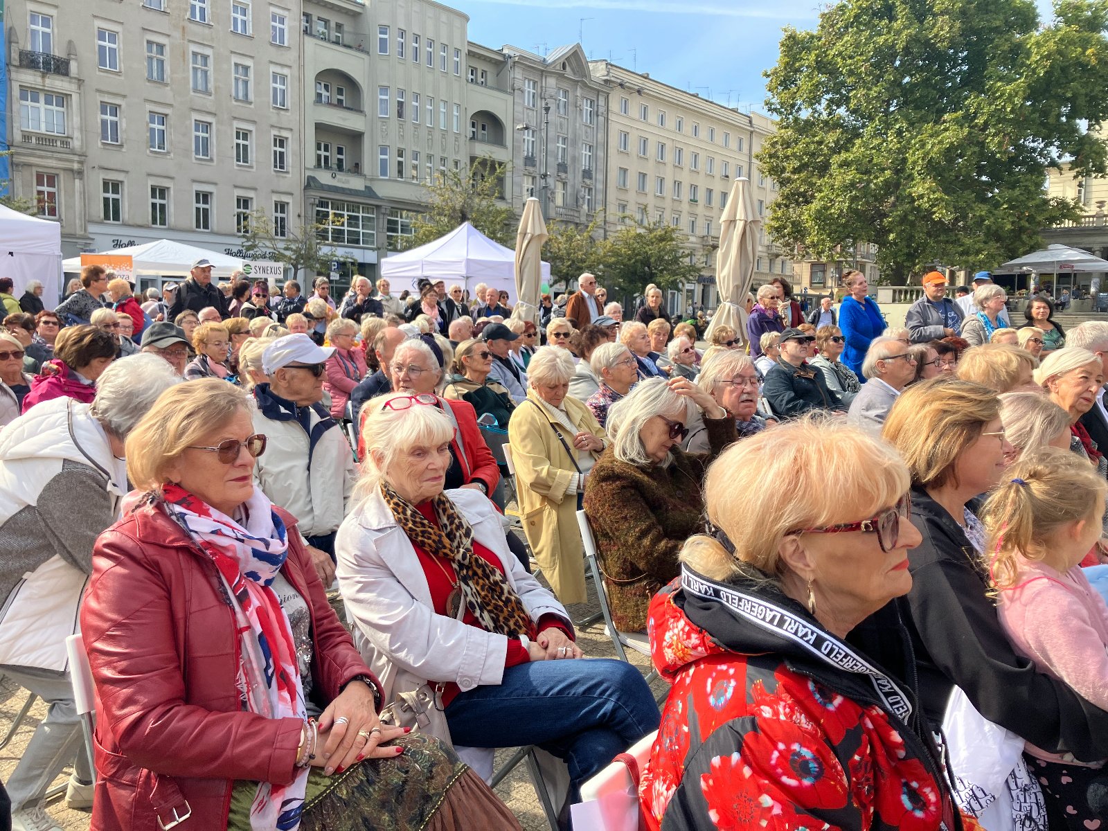 grupa seniorów siedząca na krzesełkach na placu Wolności