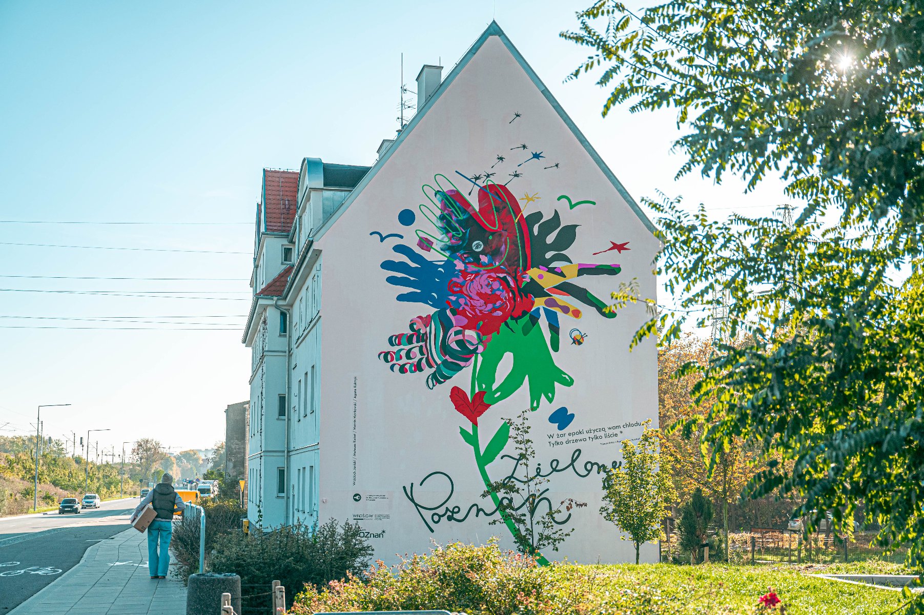 Na zdjęciu kamienica, na jej bocznej ścianie kolorowy mural - splecione dłonie - grafika artykułu