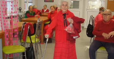 starsza kobieta ubrana na czerwono prezentuje swój czerwony strój