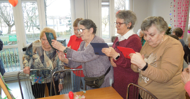 kilka starszych kobiet stoi ze smartfonami w rękach i robią zdjęcia