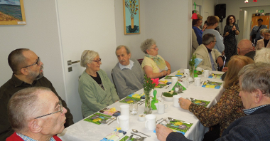 grupa seniorów siedzi przy wielkanocnym stole