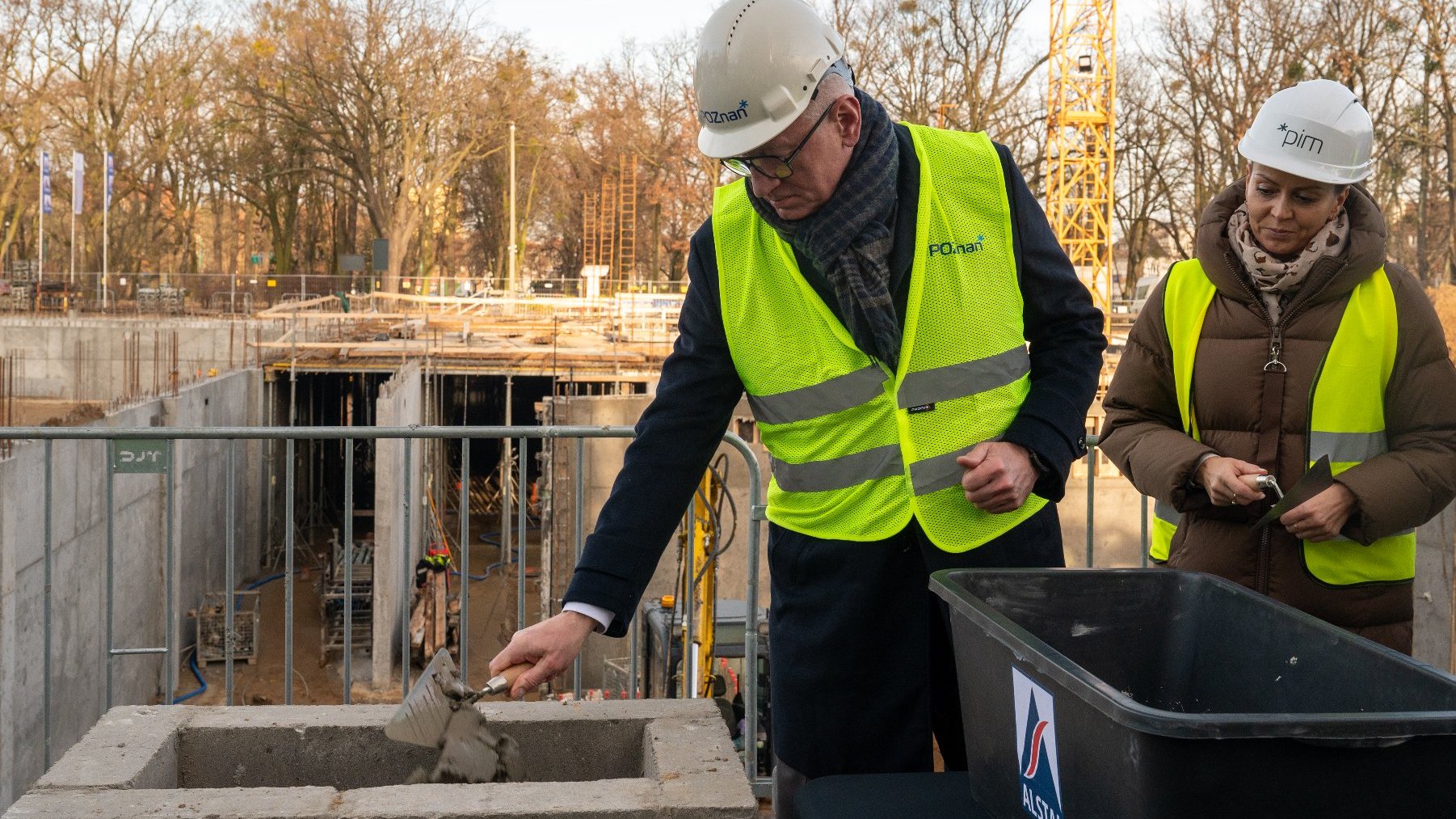 Jacek Jaśkowiak, prezydent Poznania, wrzcuca cement do miejsca, gdzie włożono kapsułę czasu