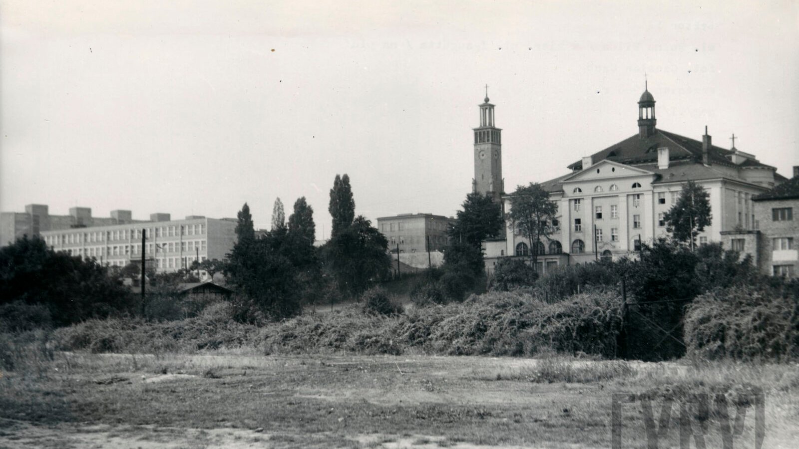 czarno-białe archiwalne zdjęcie, widok na miasto, w pierwszej liniii budynki z wieżą kościoła