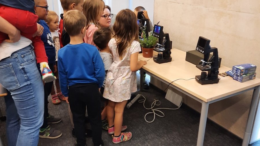 Warsztaty dla rodzin z dziećmi "W mikroświecie zapylaczy i roślin - poszukiwania i obserwacje" - uczestnicy warsztatów obserwują język pszczoły pod mikroskopem