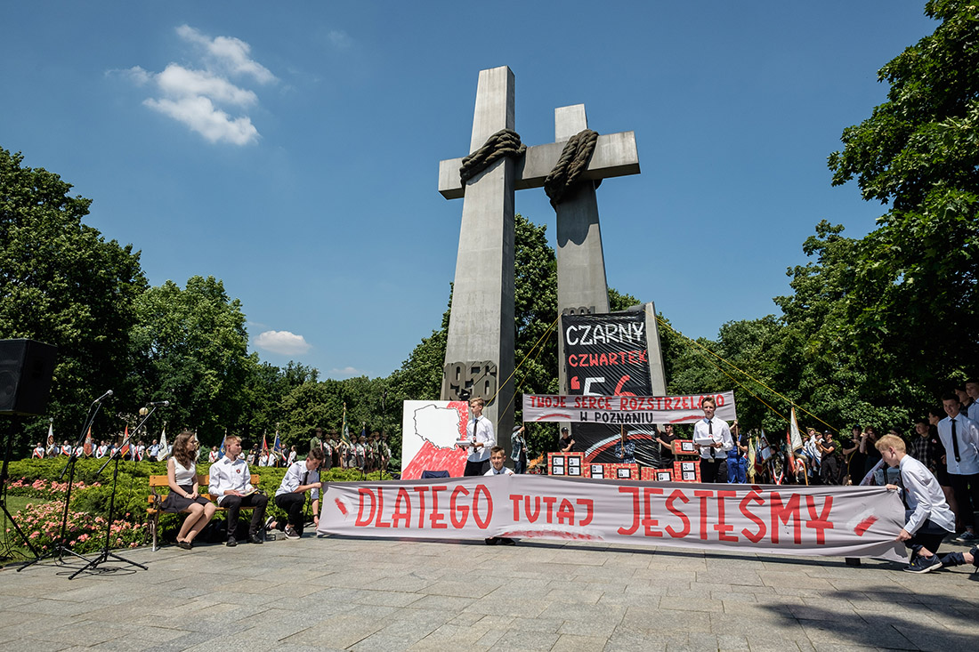 Młodzież w przedstawieniu przed pomnikiem.