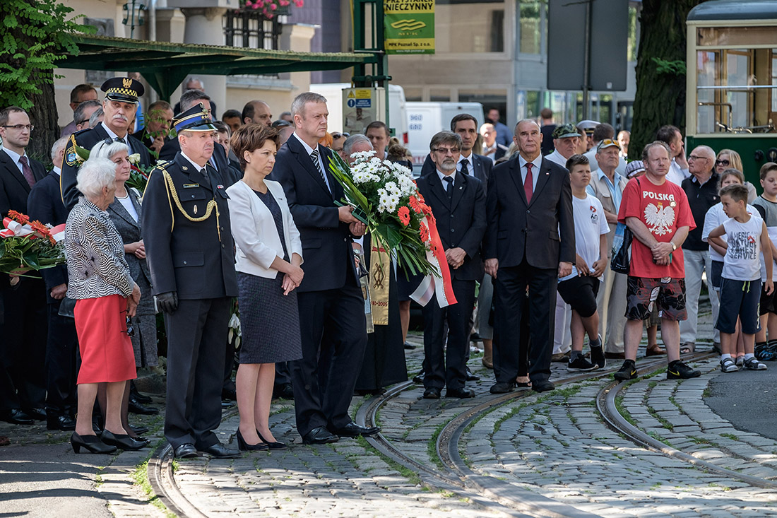 Trmawaje i składający kwiaty uczestnicy obchodów rocznicowych.