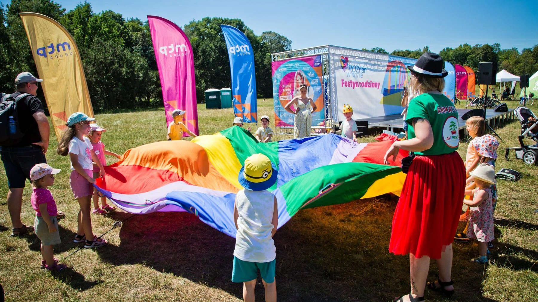 Na zdjęciu dzieci bawiące się kolorową płachtą