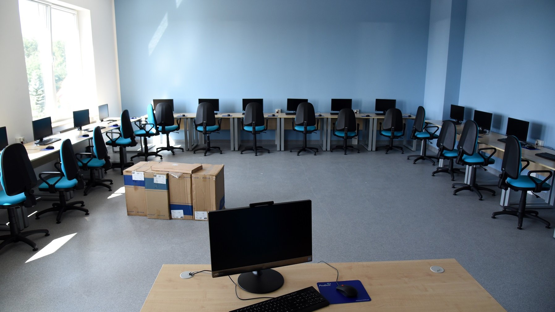 Klasa z komputerami na biurkach czeka na uczniów