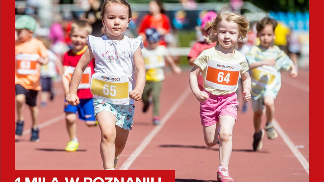 Zdjęcie, dzieci z nurmerami startowymi na koszulkach biegną po stadionie.