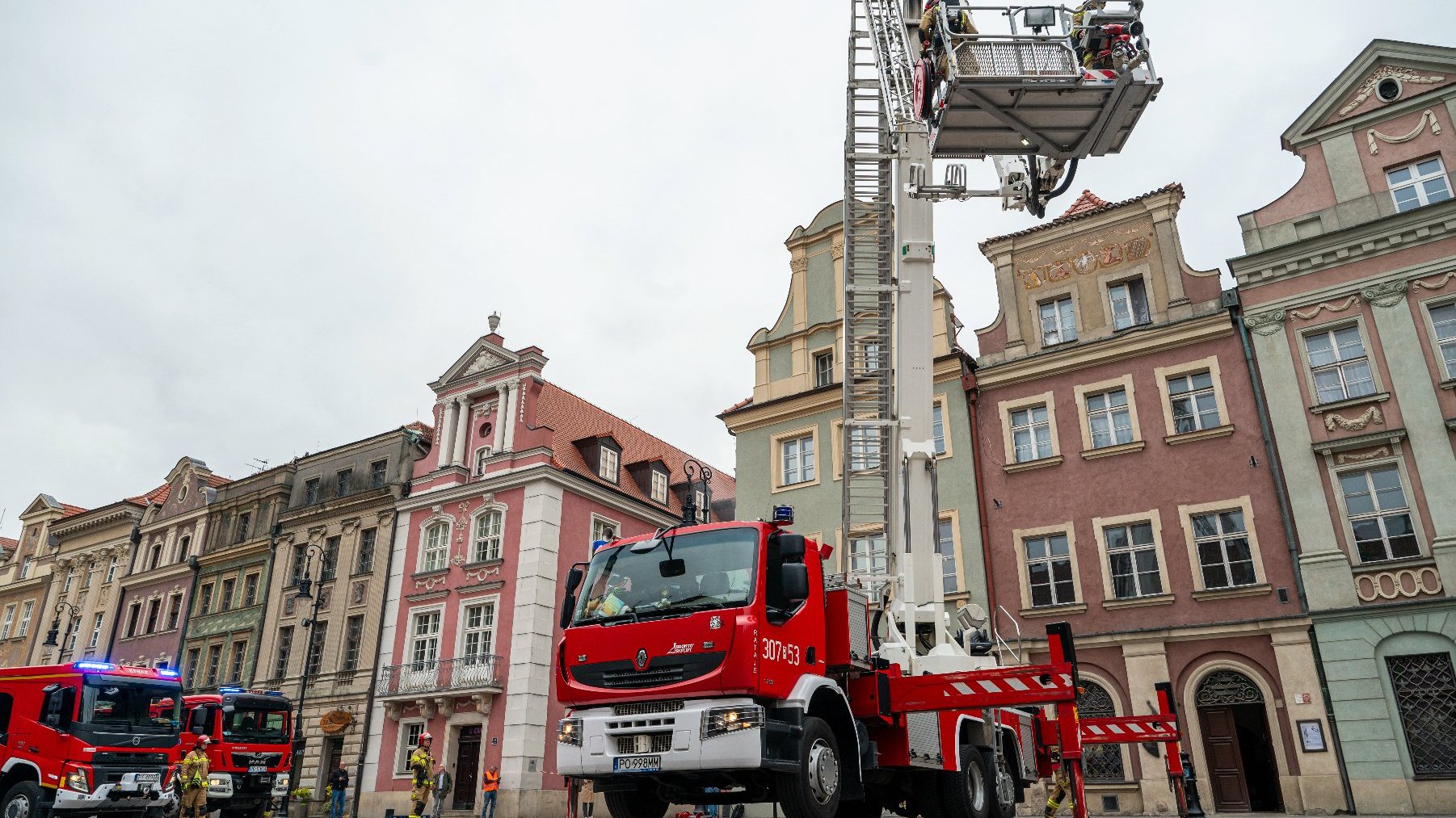 Na zdjęciu wóz strażacki, widać wyciągnięty podnośnik, na nim strażacy