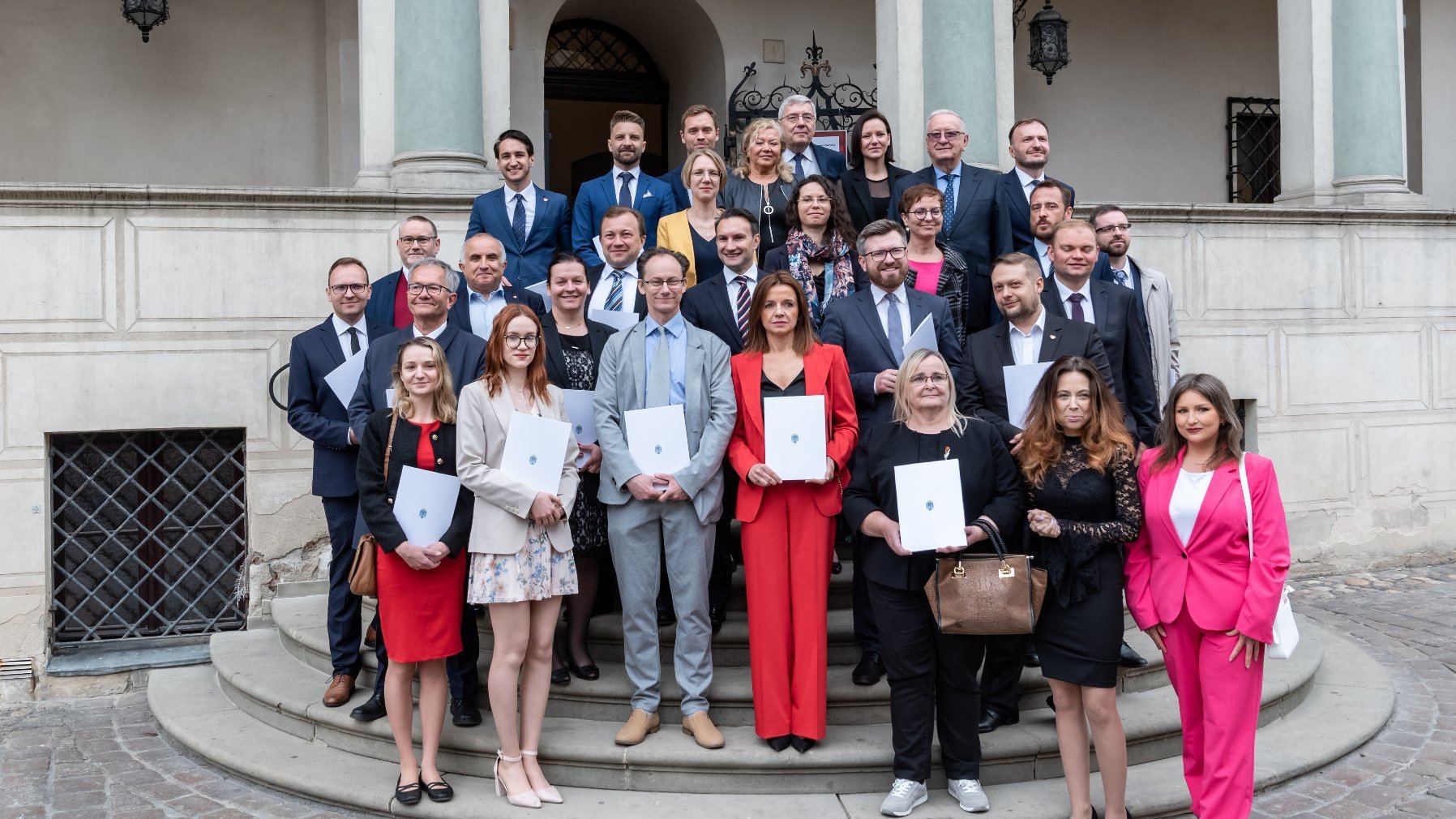 Na zdjeciu radni miasta stojący na schodach Ratusza