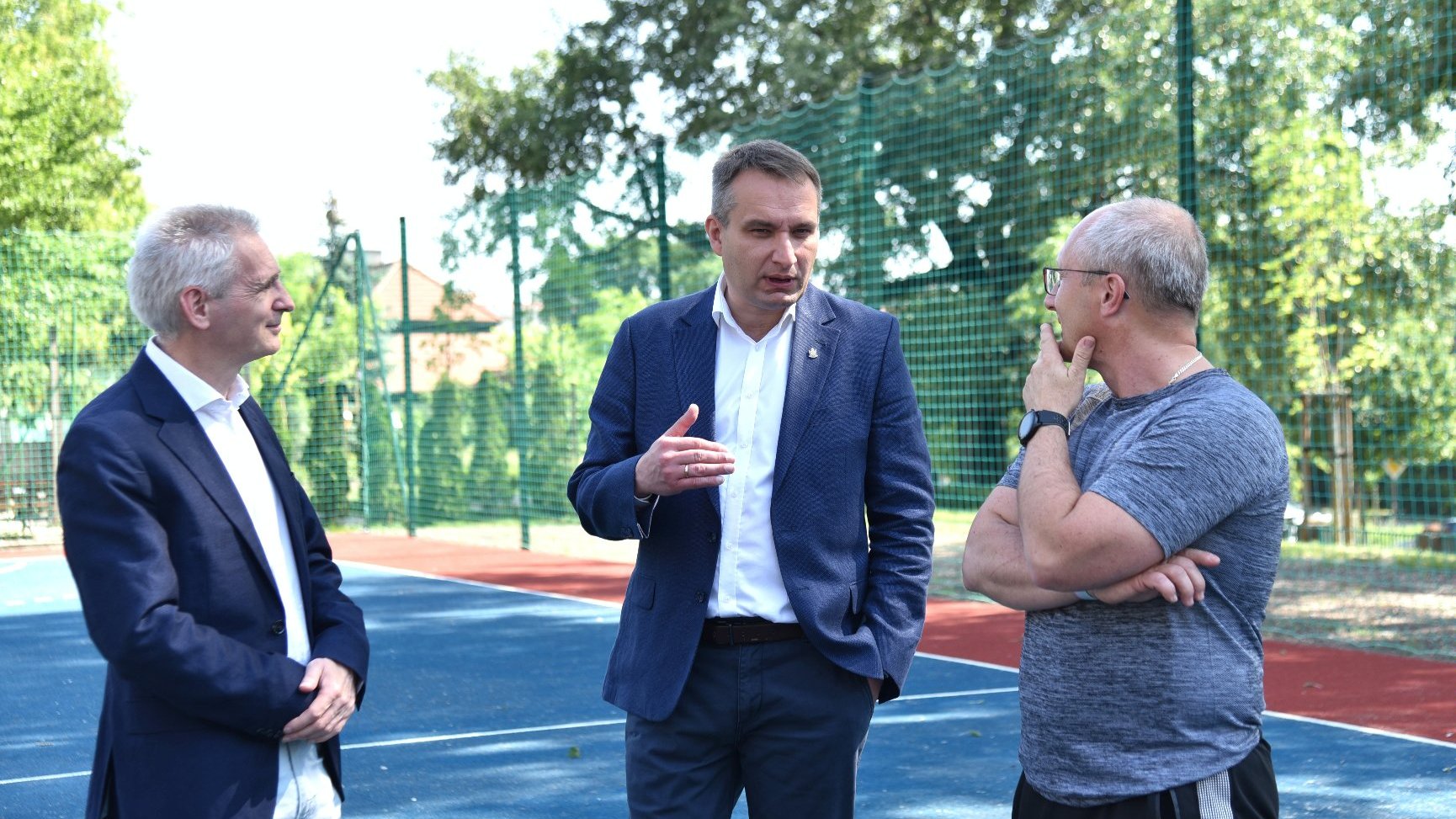 Zdjęcie przedstawia rozmawiających ludzi - wiceprezydenta, dyrektory szkoły i trenera.