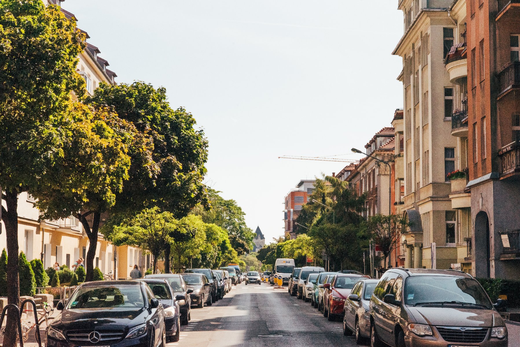 Na zdjęciu jeżycka ulica, widać kamienice, drzewa i parkujące samochody - grafika artykułu