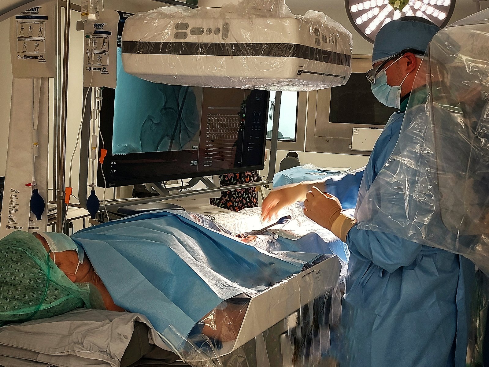 zdjęcie przedstawia chirurga podczas operacji - przed ekranem monitora, w trakcie prowadzenia zabiegu nad pacjentem - grafika artykułu