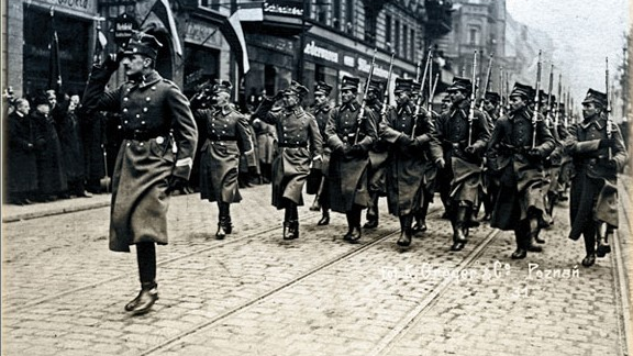 Wojska Wielkopolskie idące krokiem defiladowym po poznańskich ulicach.