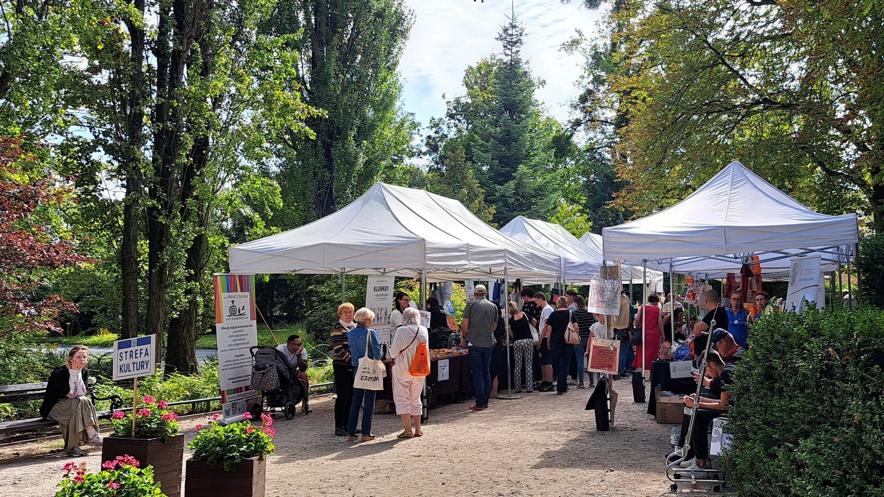 Ludzie stoją przy straganach opatrzonych napisem Strefa Kultury.