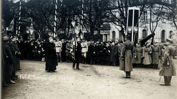 Scena wręczenia sztandarów. Widoczni są licznie zgromadzeni żołnierze i cywile.