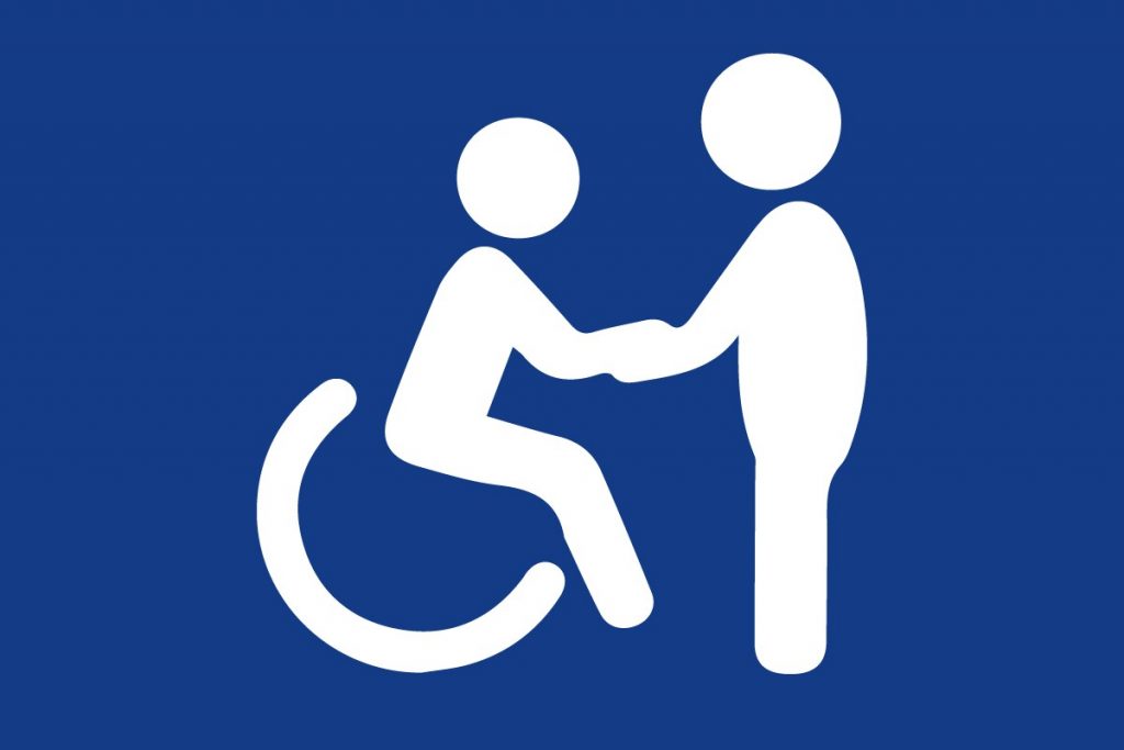Grafika przedstawia sylwetkę osoby na wózku nad którą pochyla się osoba wspierająca. - grafika artykułu