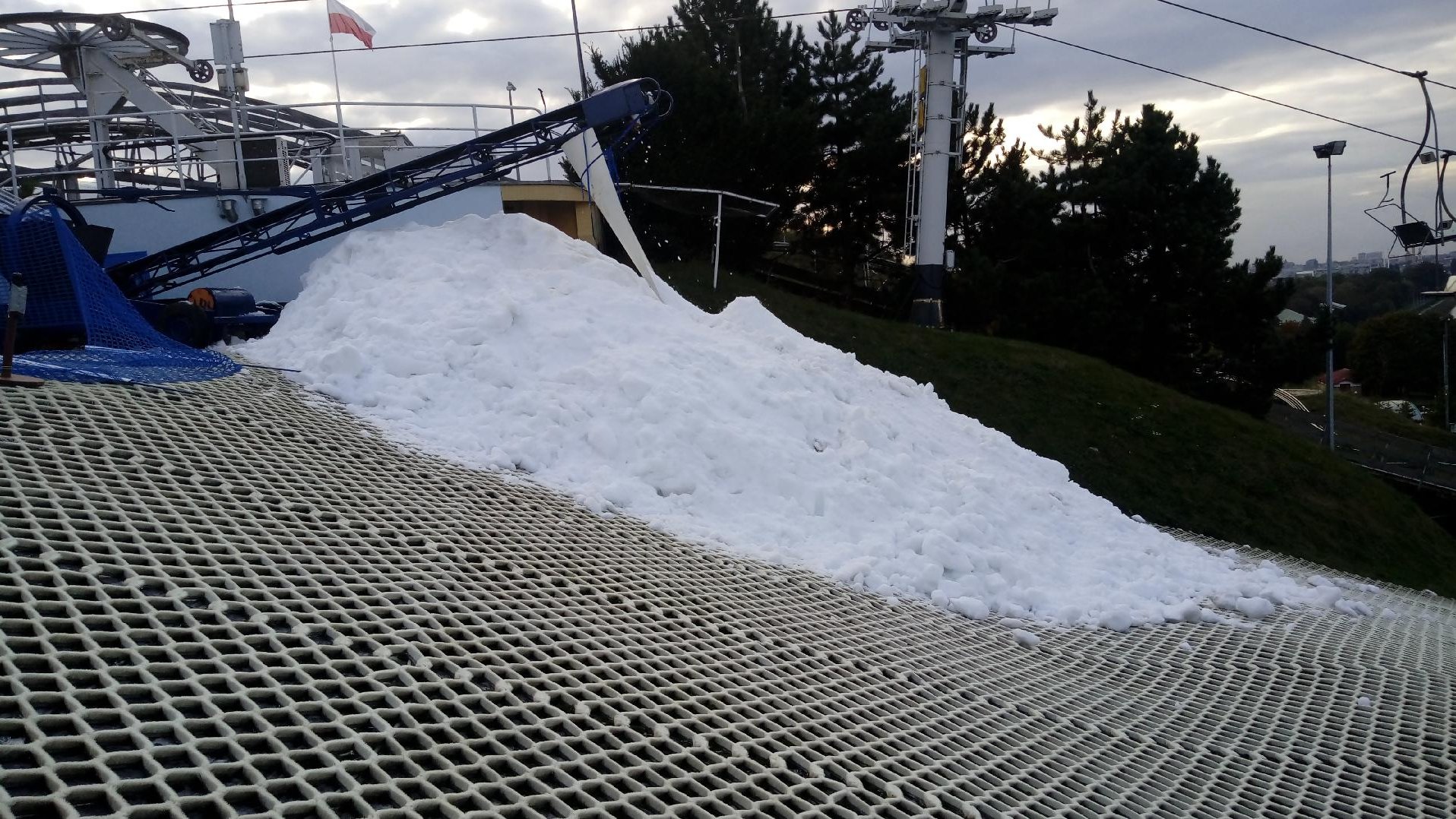 Zdjęcie przedstawia stok narciarski częściowo pokryty sniegiem.