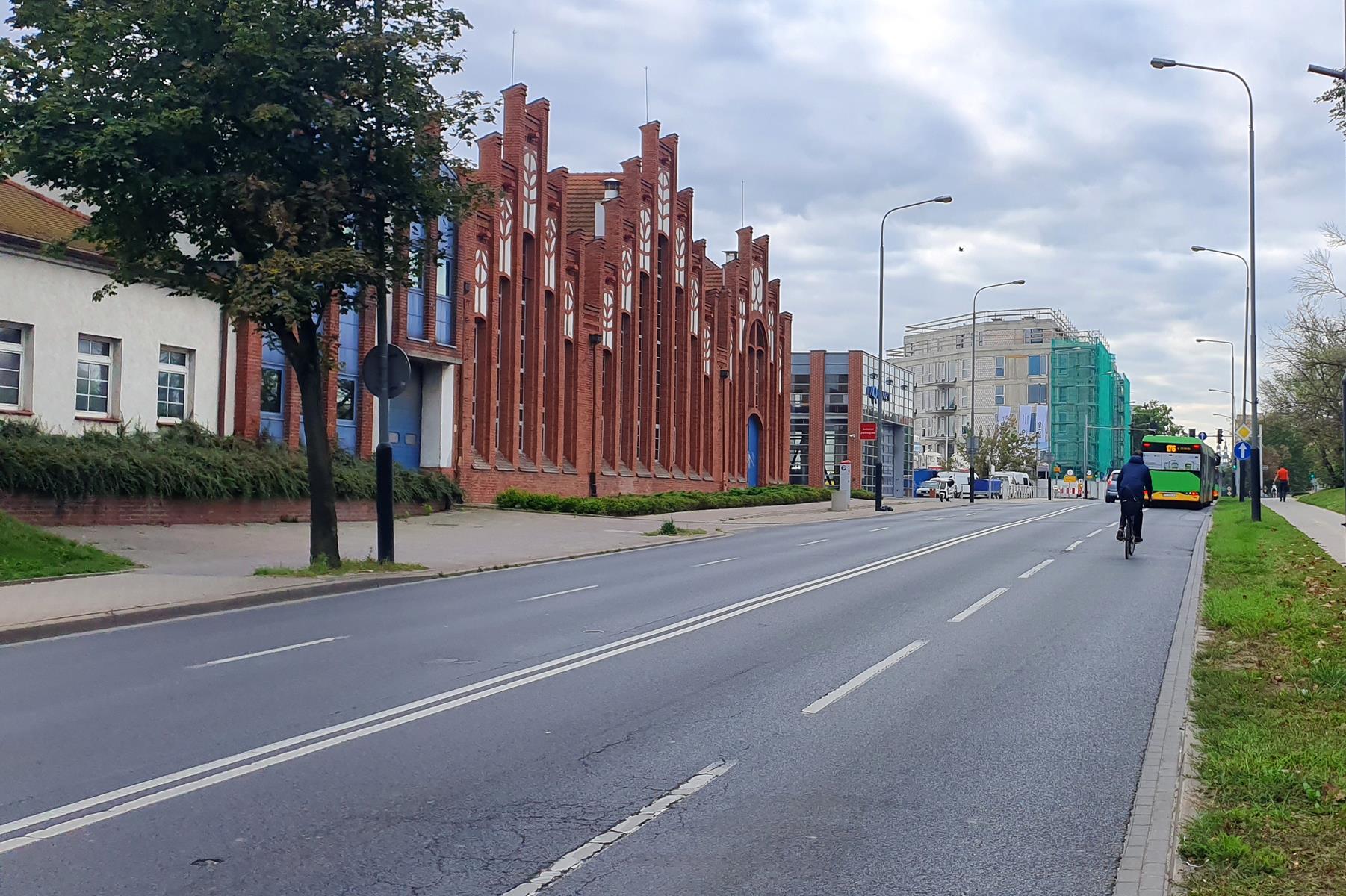 ulica Garbary. Widać rowerzystę na ulicy, a przed nim autobus. Po lewej stronie budynki Aquanetu - grafika artykułu