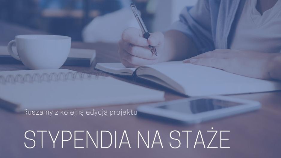 Na zdjęciu znajduje się informacja o kolejnej edycji programu stypendialnego. W tle widać ręce osoby piszącej w zeszycie, notes, filiżankę oraz telefon