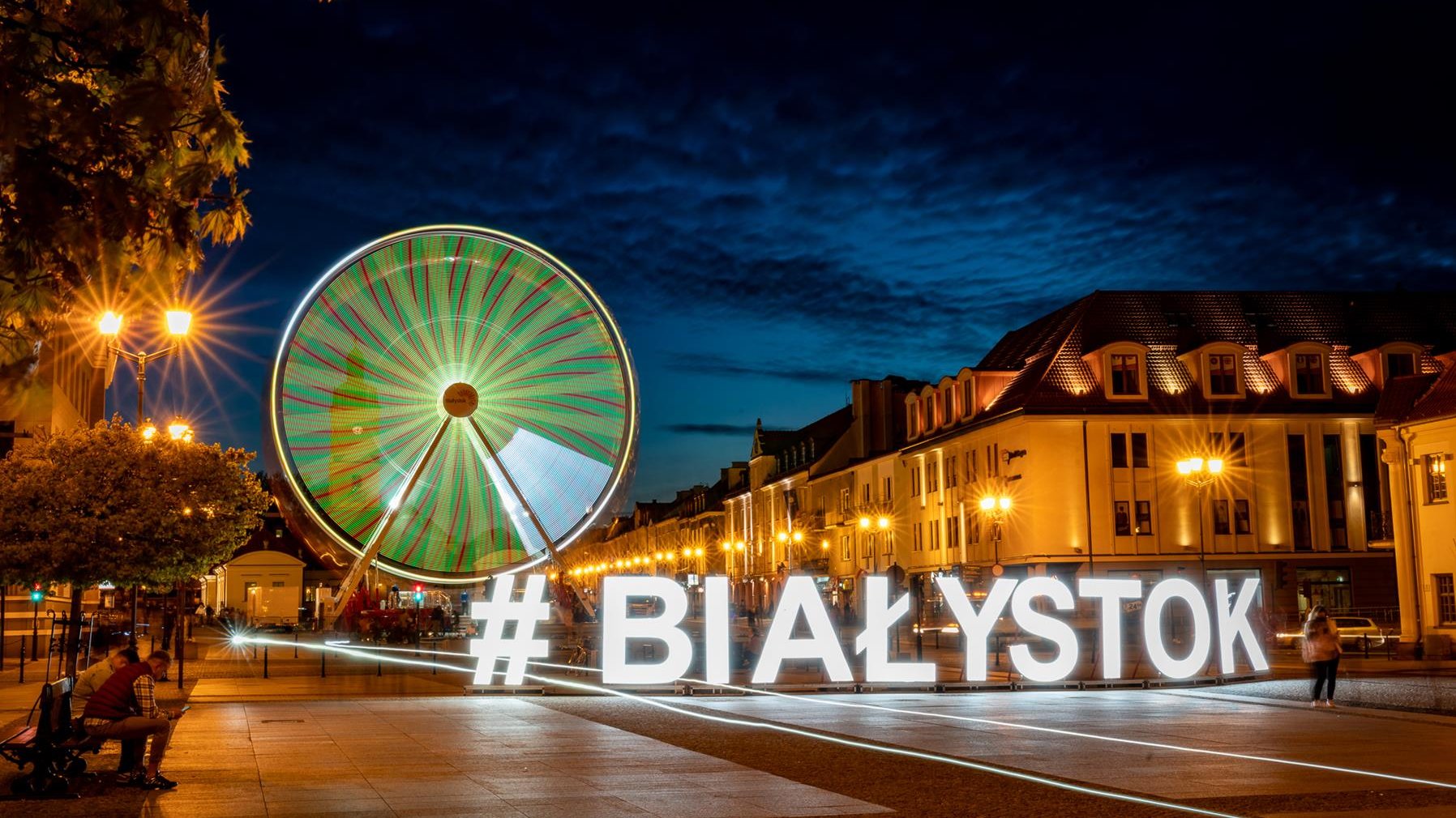 Na zdjęciu centrum miasta, diabelski młyn i duży napis: Białystok