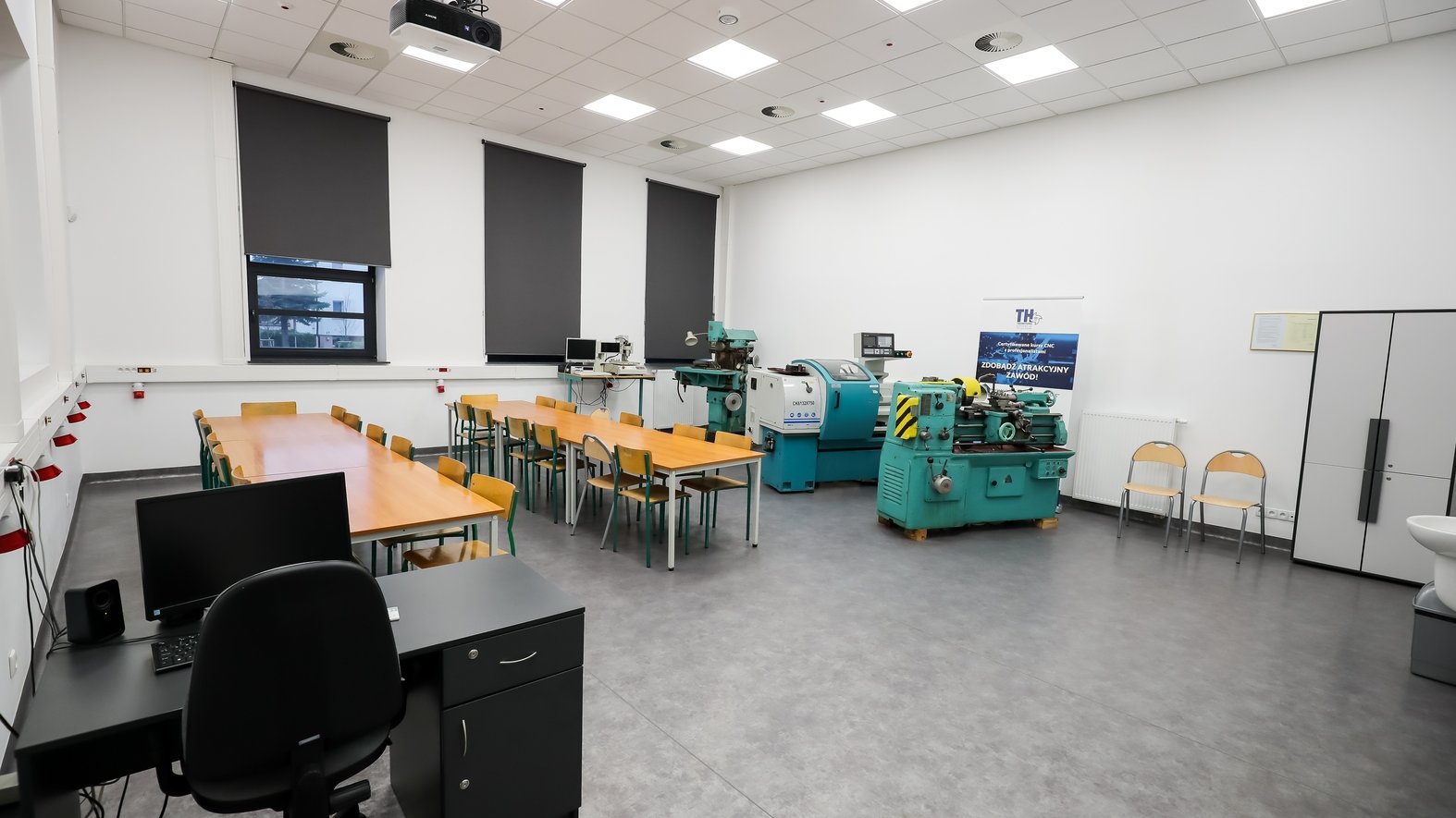 Zdjęcie przedstawia wyremontowaną salę lekcyjną. Widać na nim ławki i maszyny używane na zajęciach.