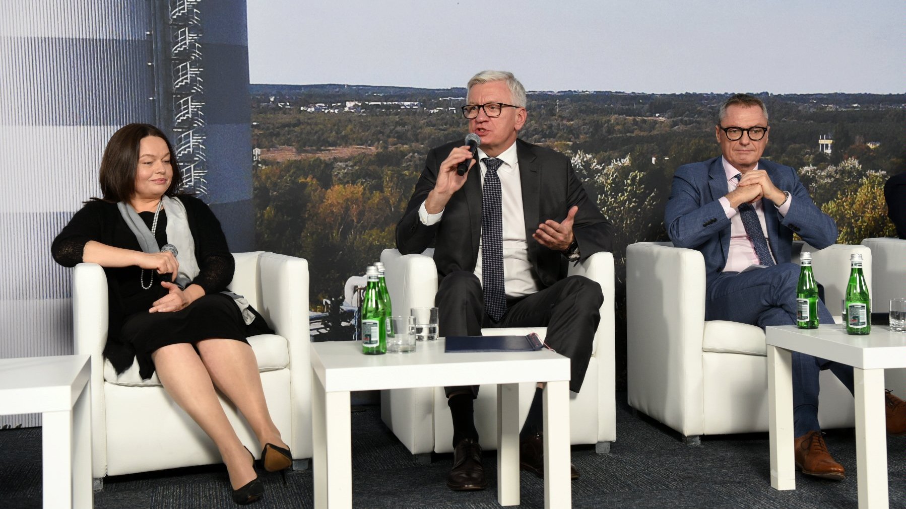 Zdjęcie przedstawia uczestników konferencji na tle zdjęcia akumulatora. Mikrofon trzyma prezydent Poznania.