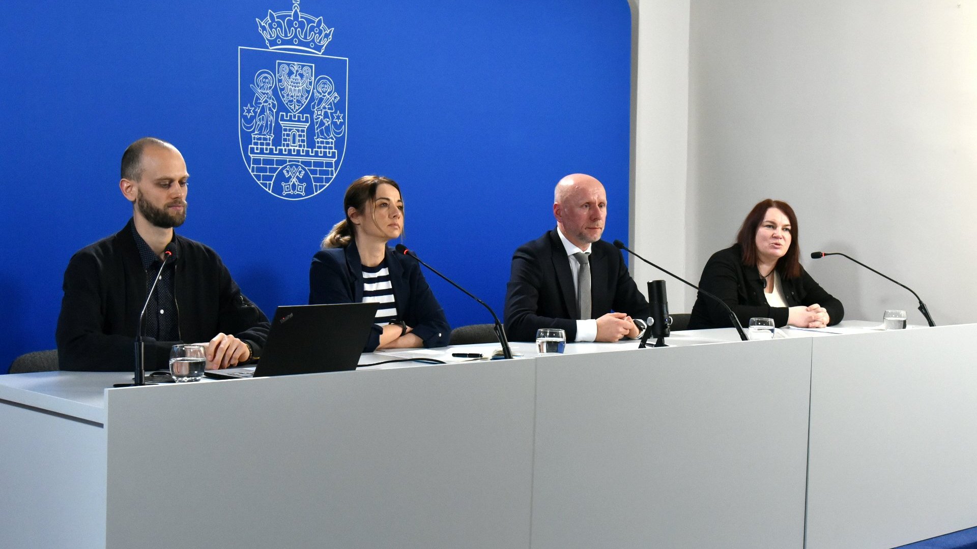 Galeria zdjęć przedstawia zdjęcia z konferencji prasowej. Widać na nich ludzi siedzących za stołem konferencyjnym.