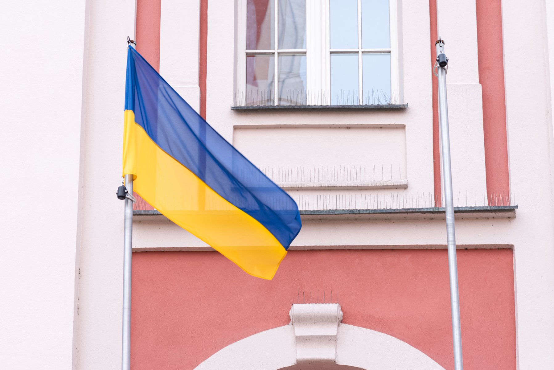 Na zdjęciu flaga Ukrainy przed urzędem miasta na placu Kolegiackim - grafika artykułu