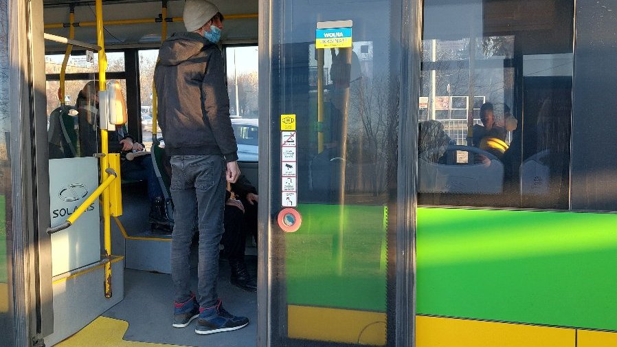 Niebiesko-żółta naklejka z napisem Wolna Ukraina po polsku i ukraińsku naklejona na drzwiach autobusu