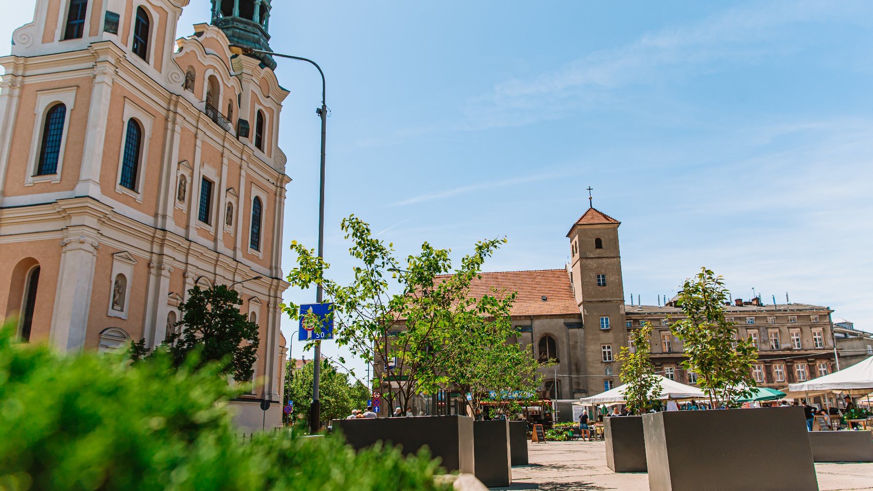 Galeria zdjęć przedstawia plac Bernardyński. Widać na nich donice z roślinami oraz stragany handlowe.