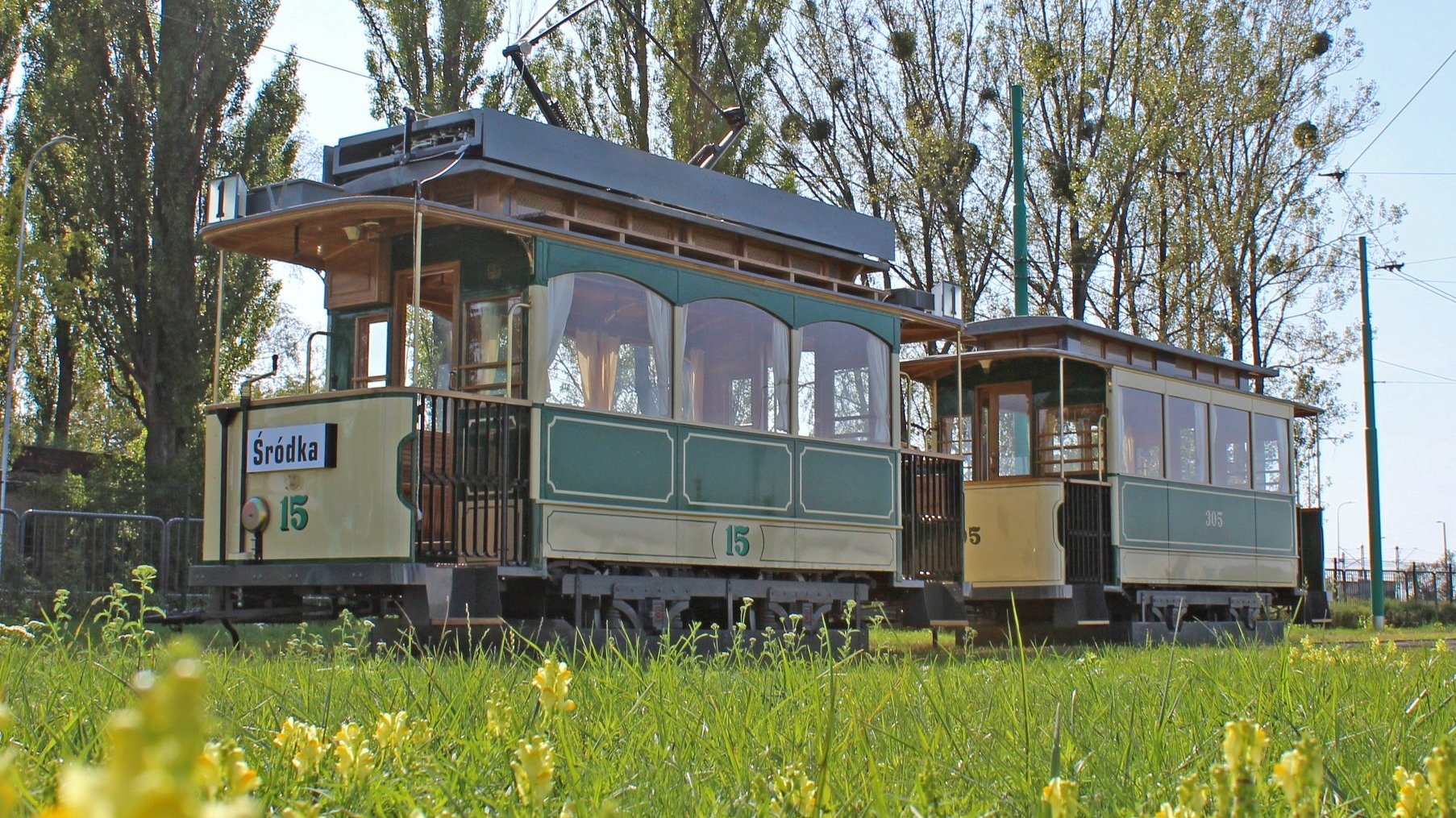 Na zdjęciu zabytkowy tramwaj stojący na torach, na pierwszym planie trawnik