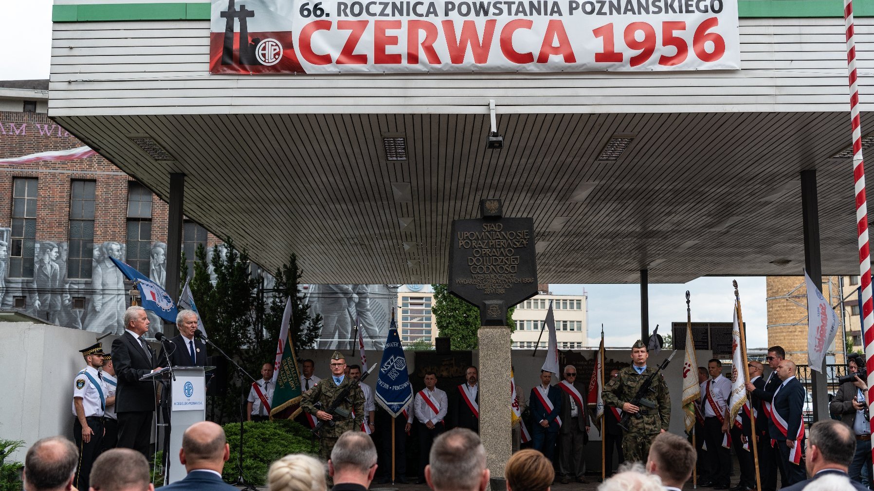 Na zdjeciu obchody przy tablicy pod bramą H. Cegielskiego, widać napis: 66. rocznica Powstania Poznańskiego Czerwca 1956