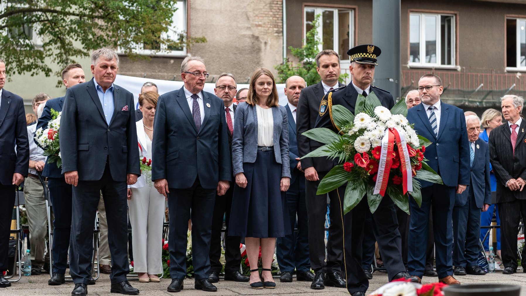 Na zdjęciu delegacja władz samocrządowych składająca kwiaty, na pierwszym planie strażnik z wiązanką