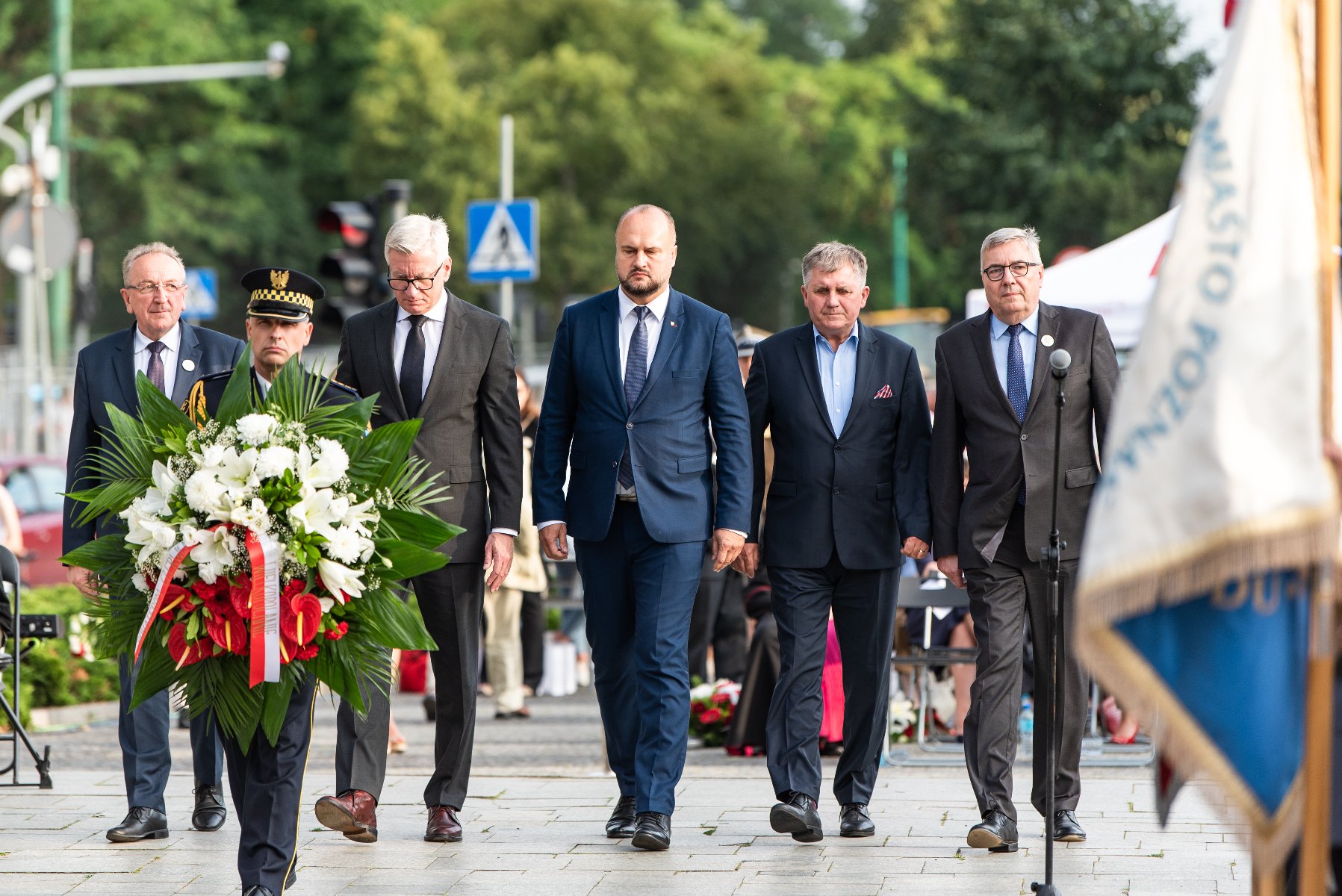 Na zdjęciu przedstawiciele władz Miasta i regionu składają kwiaty pod pomnikiem, na pierwszym planie strażnik z wiązanką - grafika artykułu