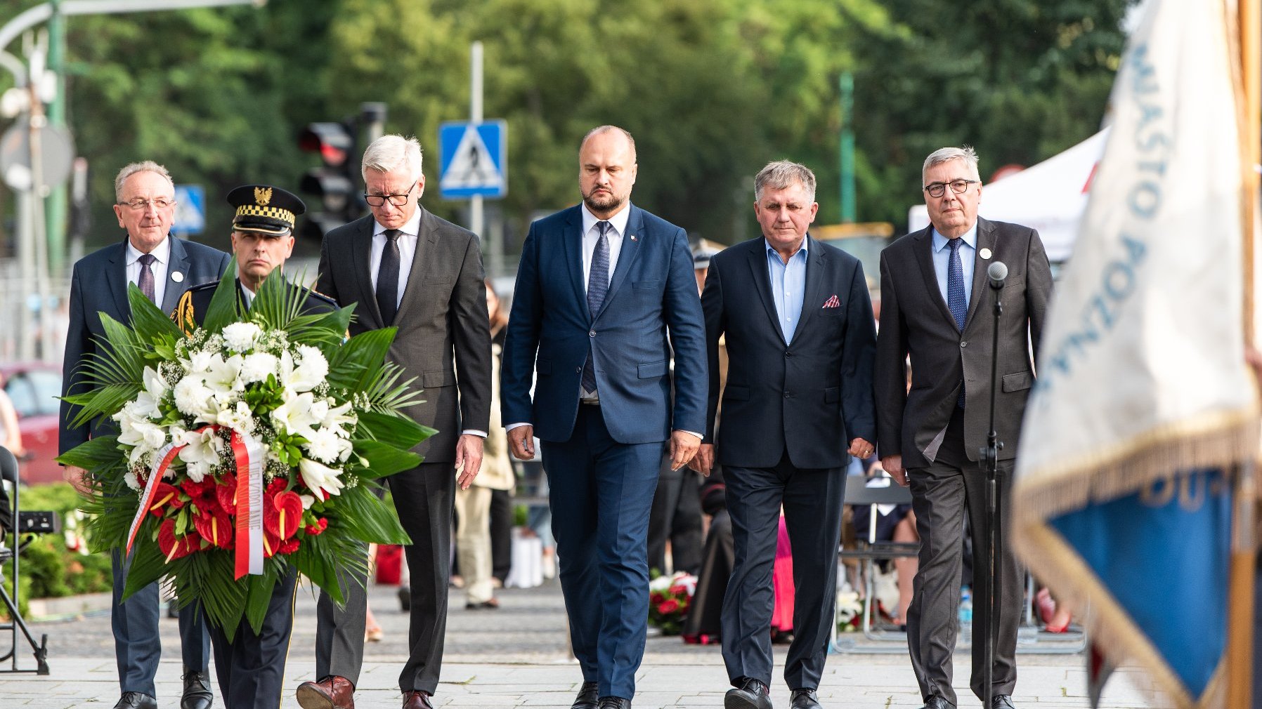 Na zdjęciu przedstawiciele władz Miasta i regionu składają kwiaty pod pomnikiem, na pierwszym planie strażnik z wiązanką