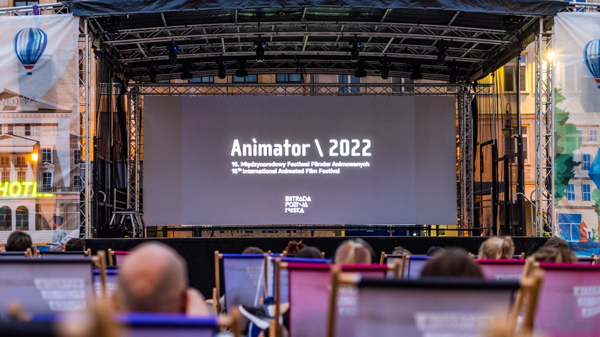 Na zdjęciu ekran z napisem: animator 2022, przed nim siedzą ludzie na leżakach