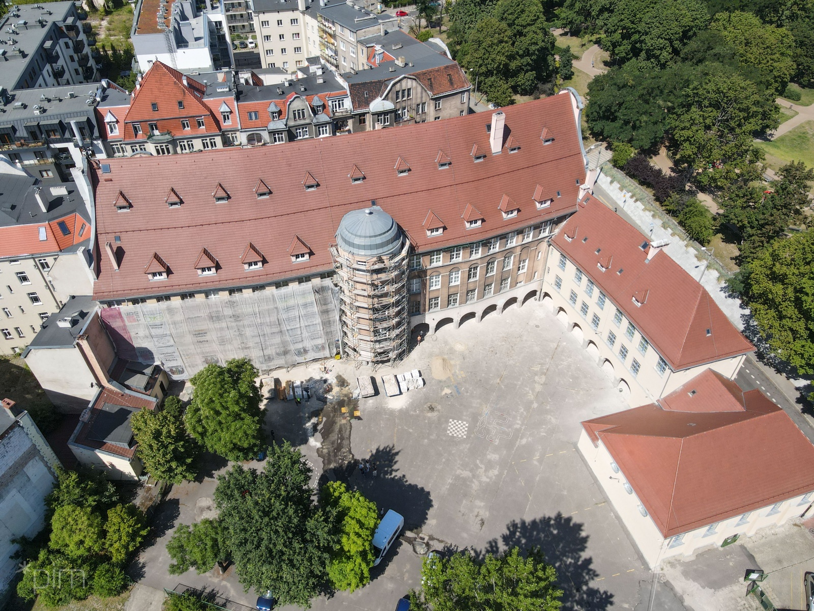 Zdjęcie pokazuje dziedziniec szkoły przy ul. Różanej. Po prawej stronie elewacja niższego budynku została już odnowiona. Teraz zasłonięta jest część po lewej od wieżyczki - grafika artykułu