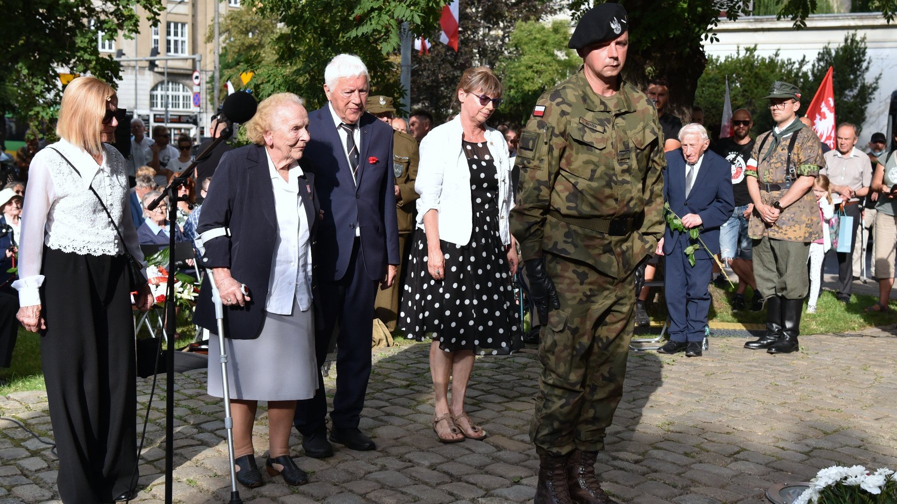 Na zdjęciu grupa ludzi składających wiązankę