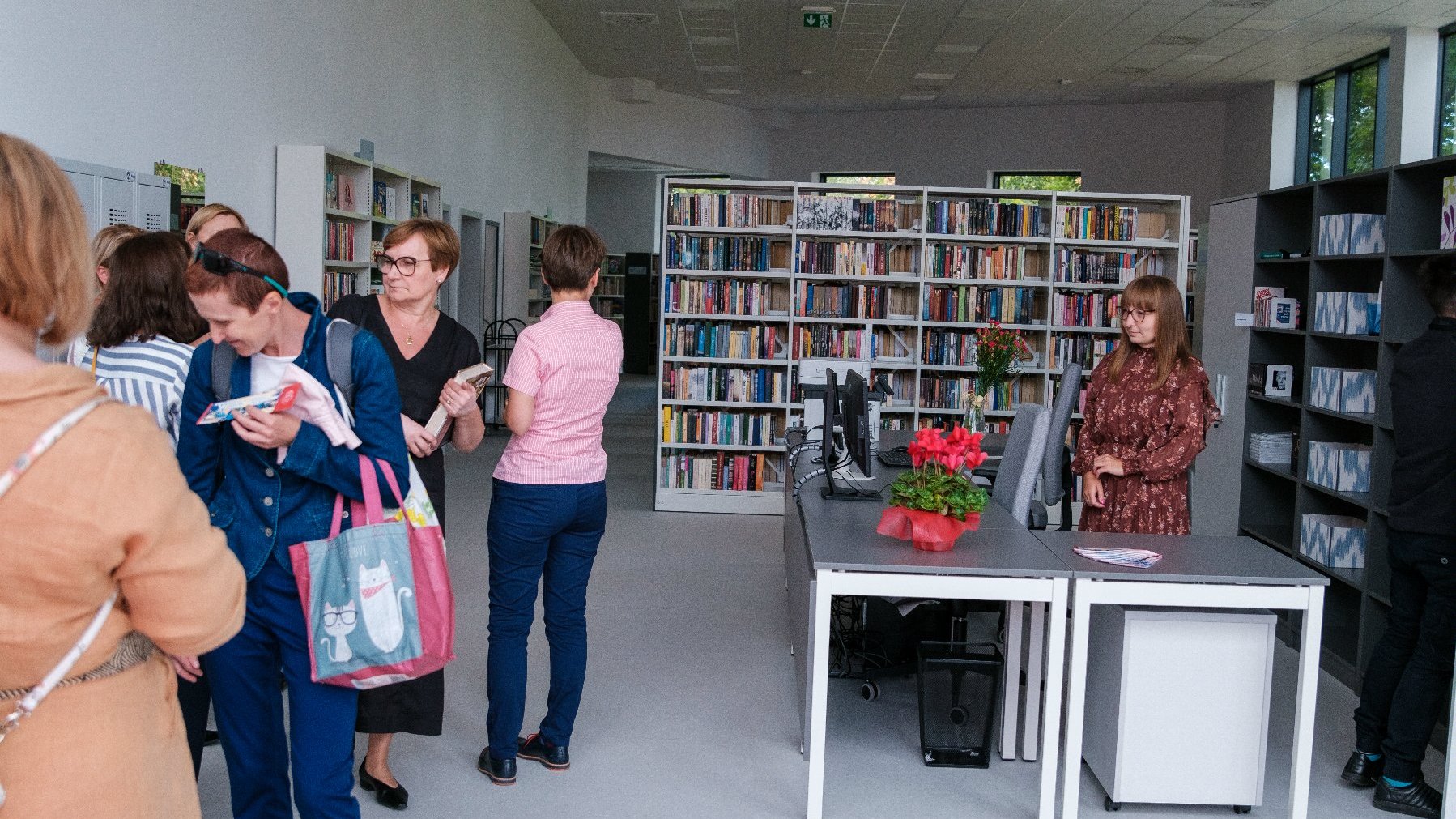 Na zdjęciu wnętzre biblioteki z ludźmi