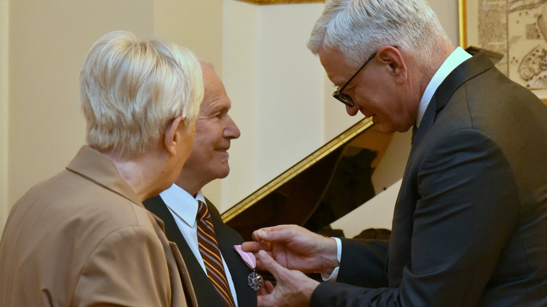 Na zdjęciu prezydent Poznania przypinający medal mężczyźnie, obok którego stoi jego żona