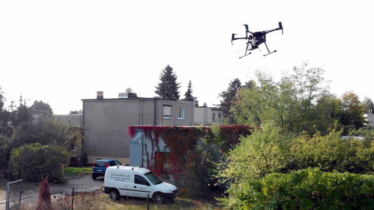 Na zdjęciu widok na budynki oraz latający dron