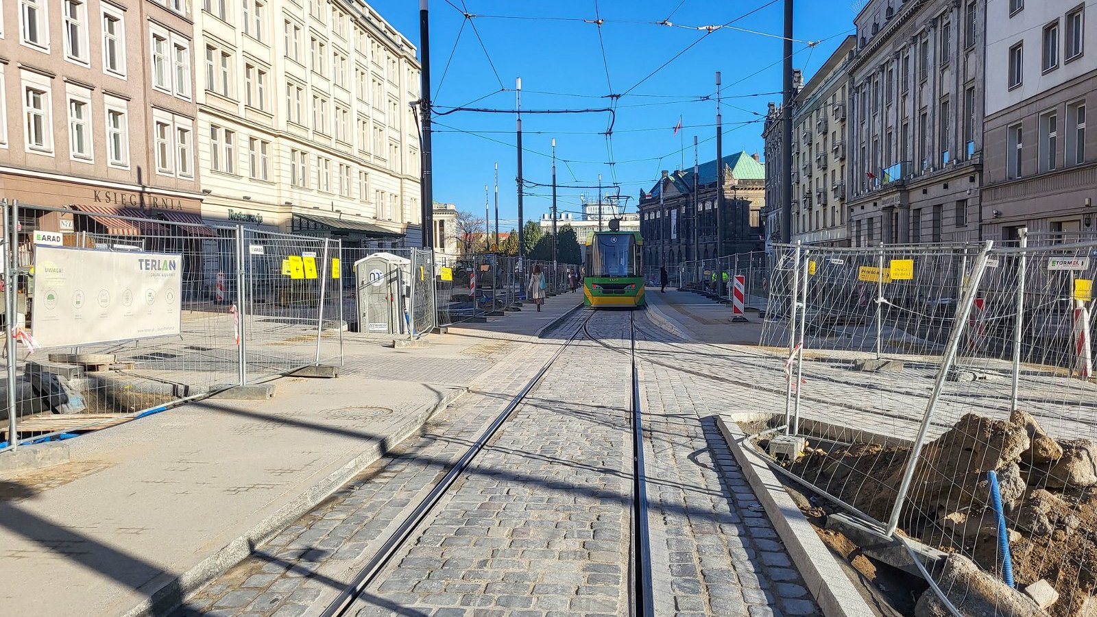 Na zdjęciu Al. Marcinkowskiego, w centrum szyny, w oddali widać tramwaj na przystanku