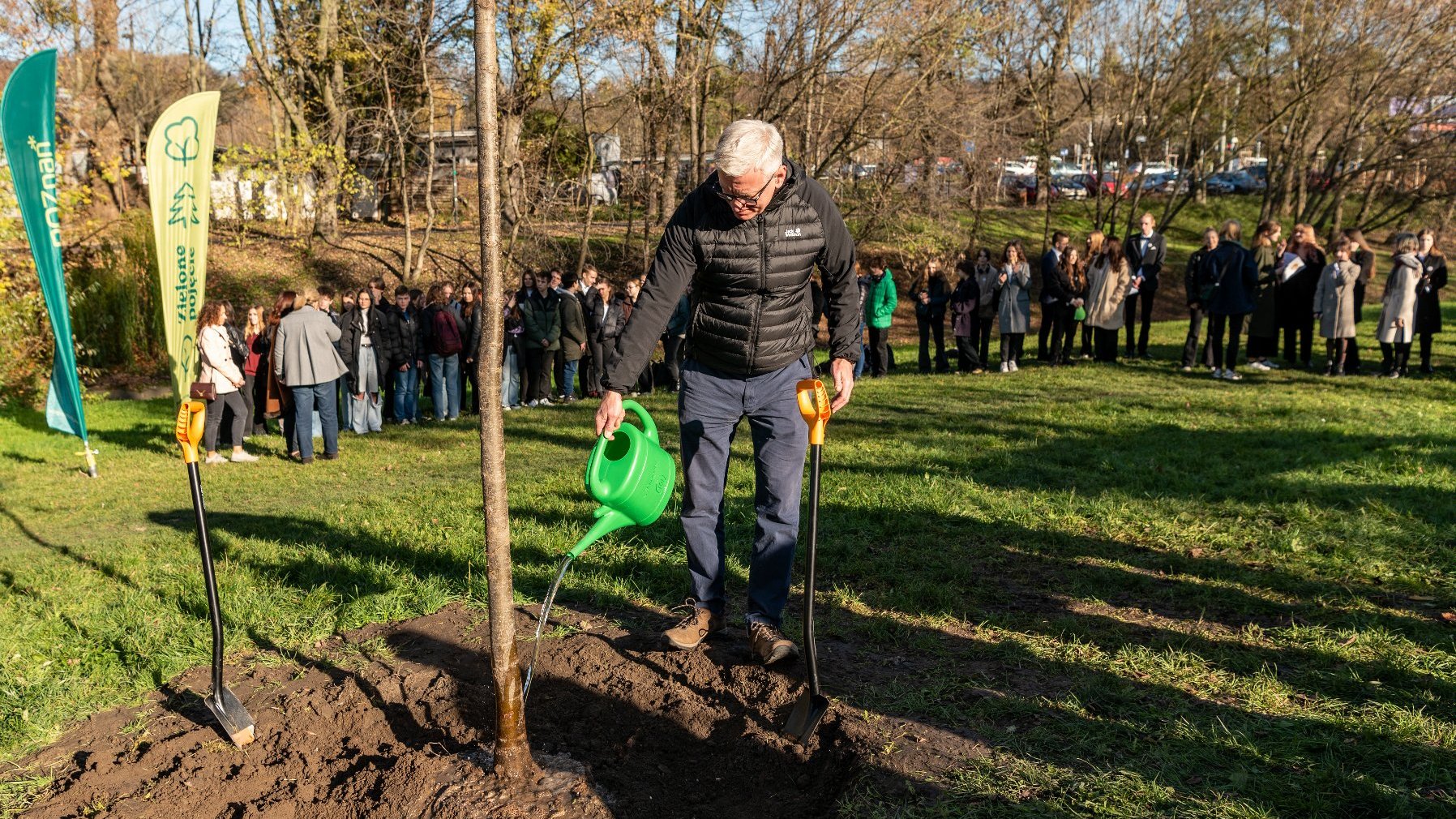 Na zdjęciu prezydent Poznania podlewający dzrewo konewką