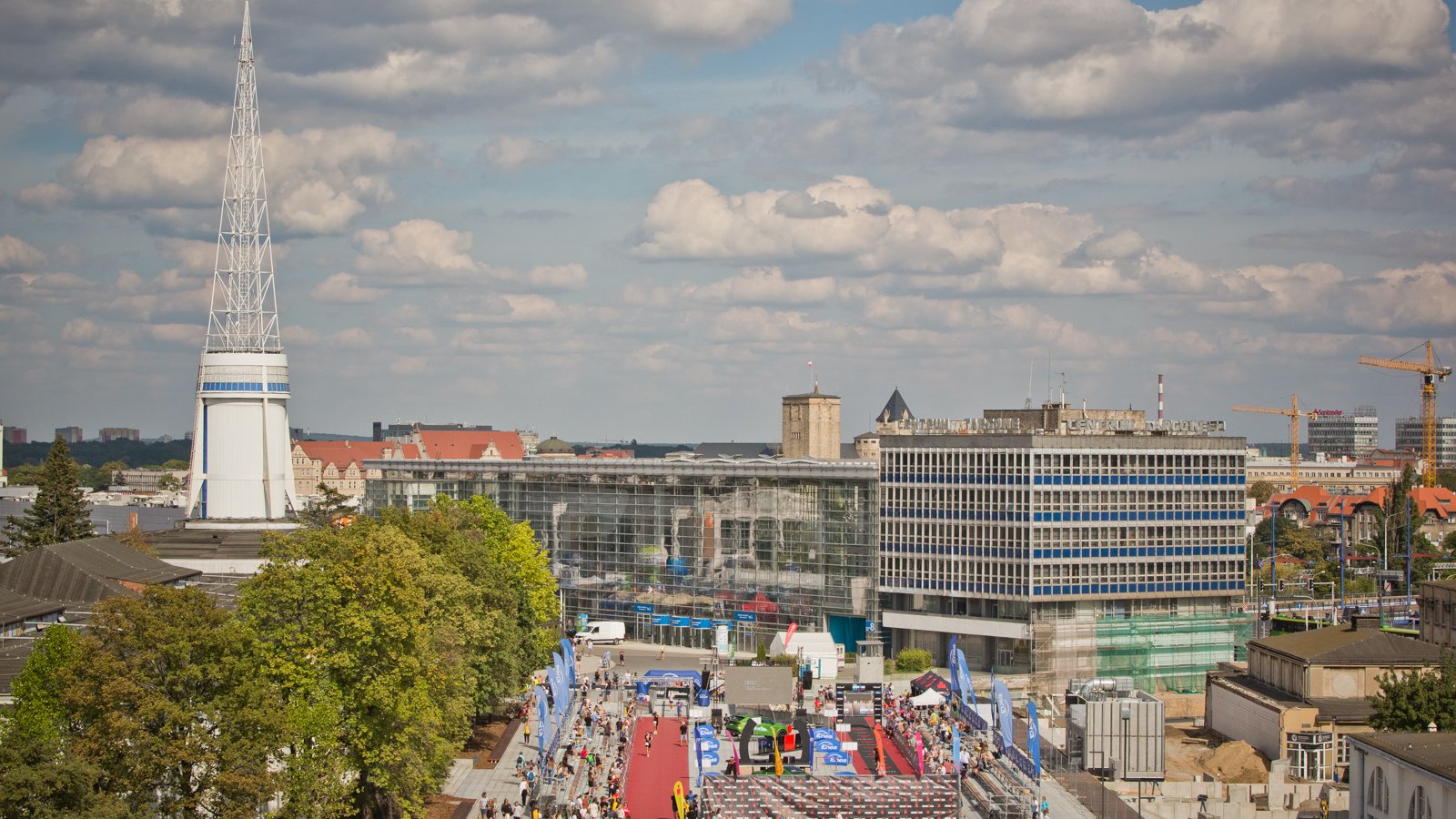 Na zdjęciu plac, w centrum ludzie, w tle Iglica