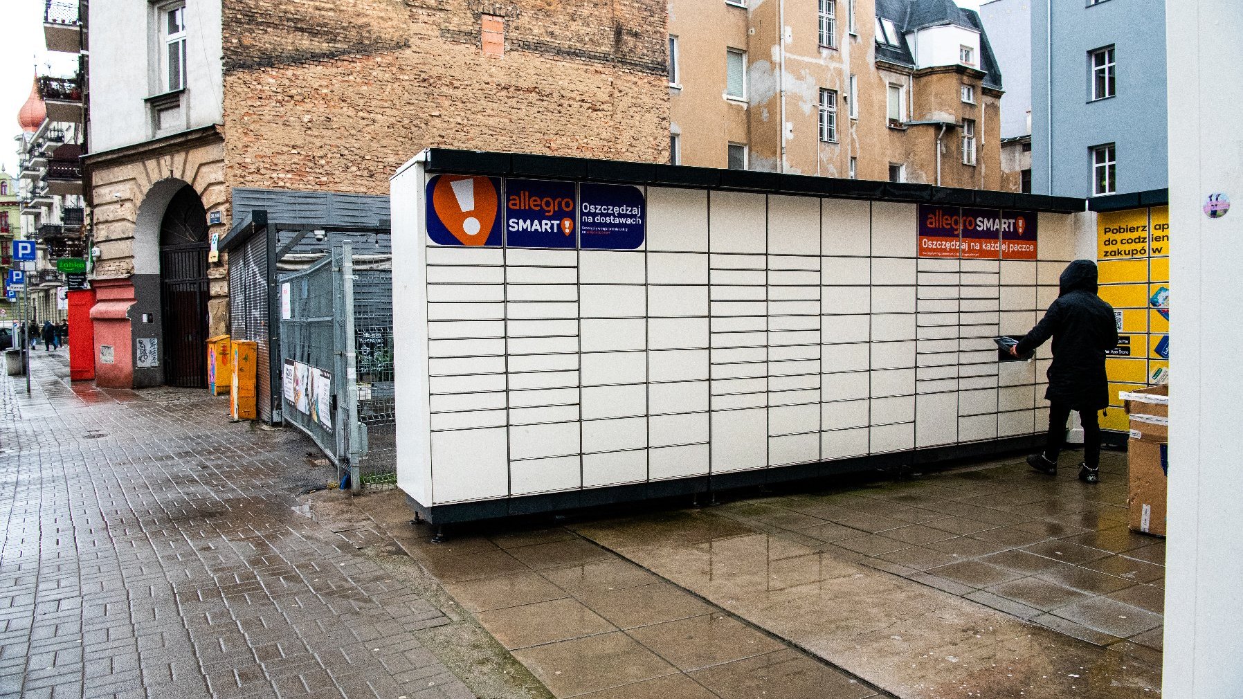 Galeria zdjęć przedstawia automaty paczkowe ustawione w centrum miasta.